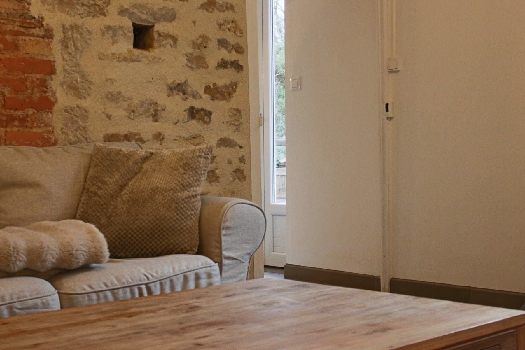 Le salon et son mur en pierre apparente